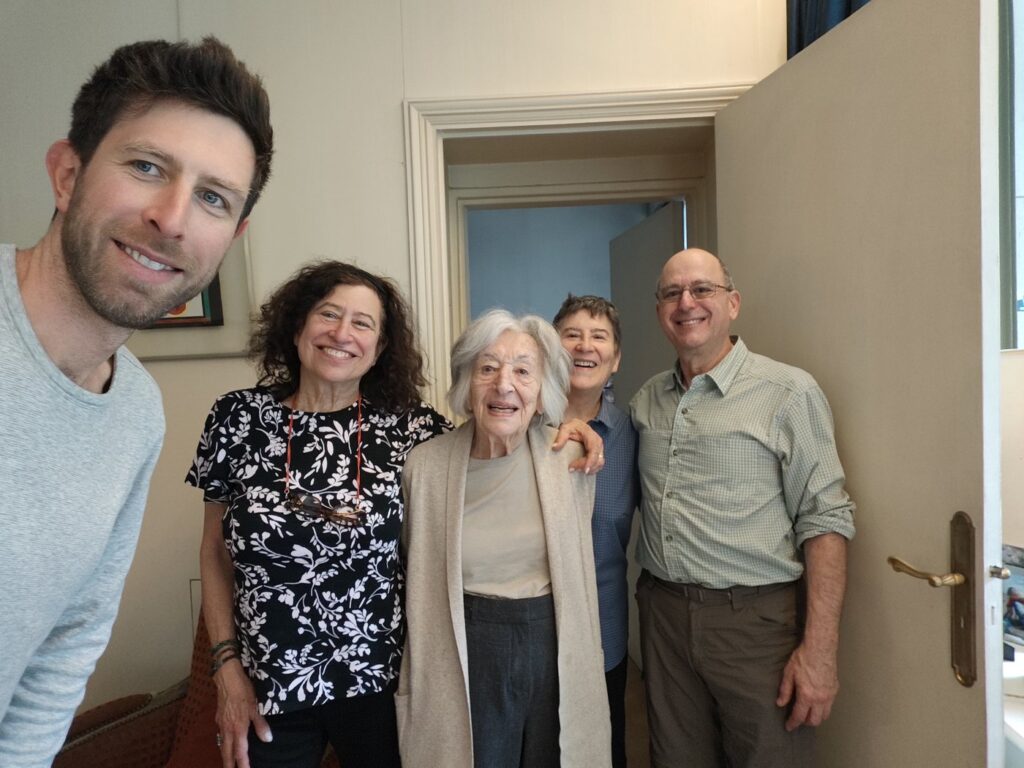 Group selfie with five people including an elderly woman in the center, at an apartment in the 16th arrondissement