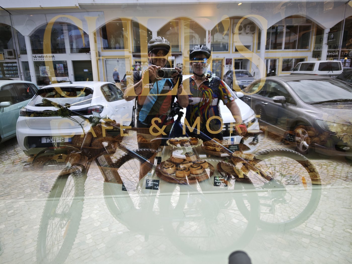 Reflection of two cyclists with helmets in a shop window
