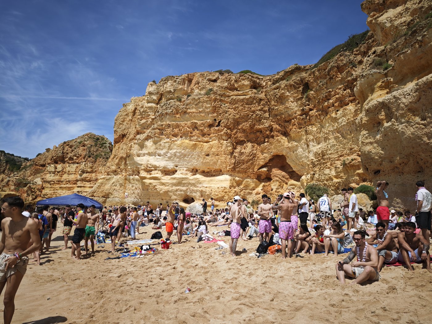Crowded Praia da Marinha beach with golden sandstone cliffs