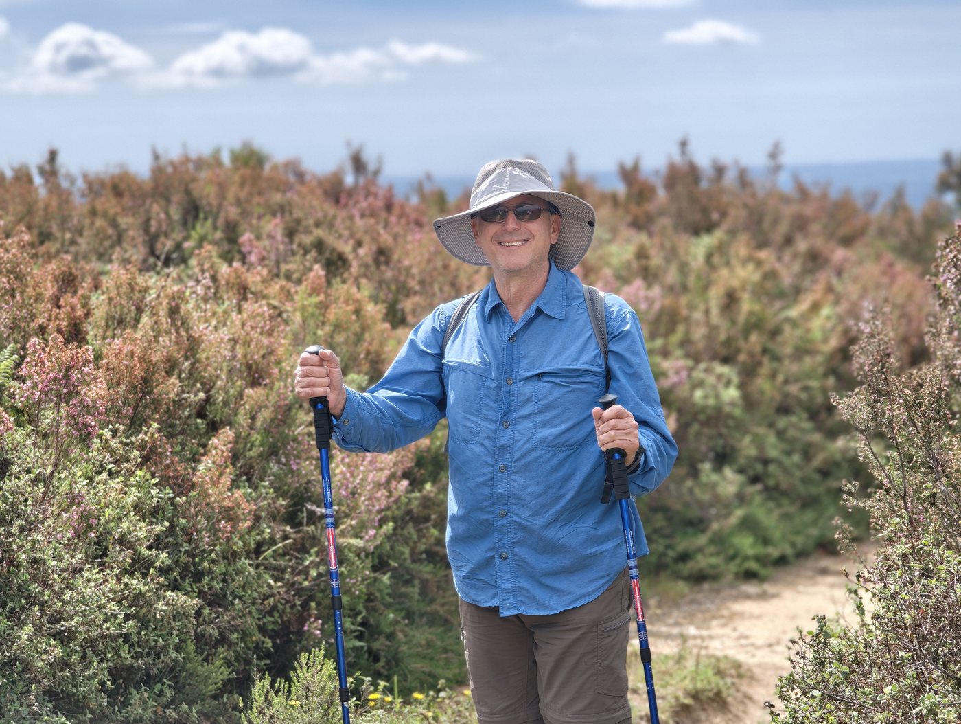 Kathy hiking through flowering scrub on the Foia trail