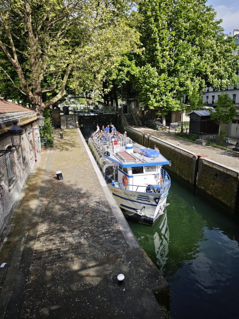 A barge passing through a canal lock on the Canal Saint-Martin in Paris viewed from above
