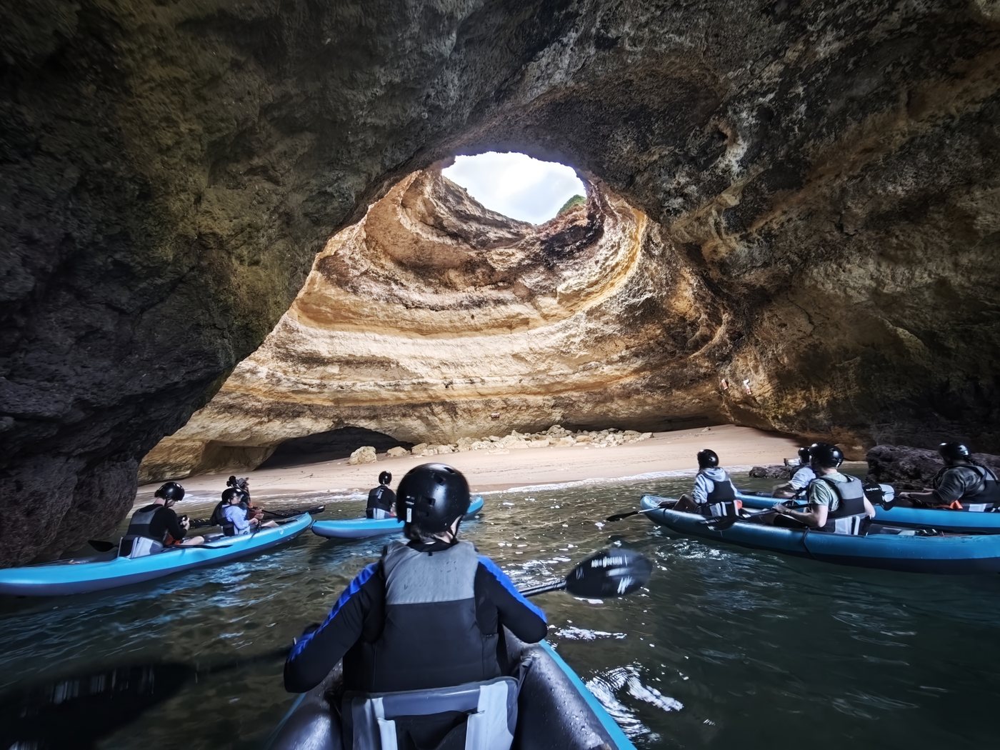 Kayakers paddling into the Benagil sea cave at dawn