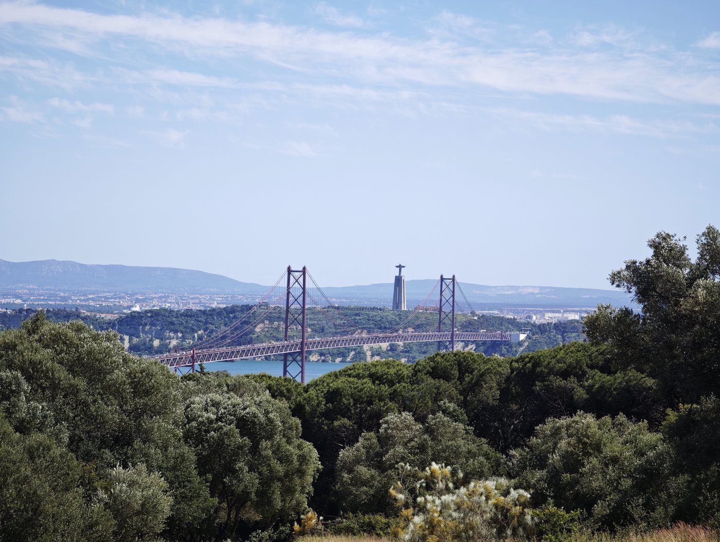 The 25 de Abril Bridge and Cristo Rei seen from the hills of Monsanto park