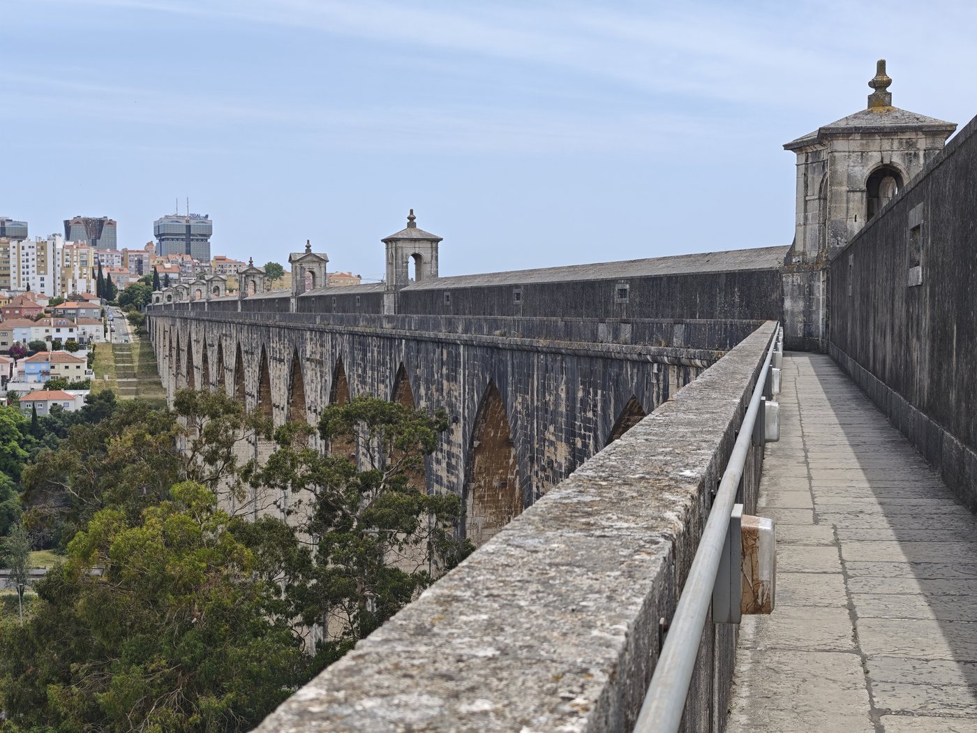 Walking along the top of the Águas Livres Aqueduct with Lisbon visible in the distance